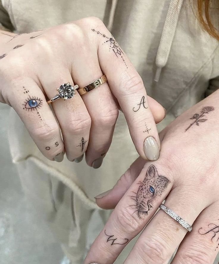 two people with matching tattoos on their fingers holding each other's hands and looking at the camera