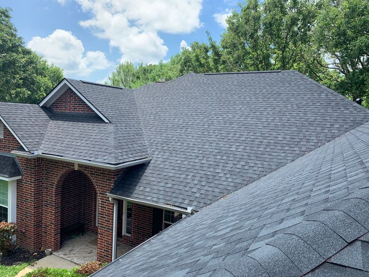 the roof of a brick house is covered in shingles