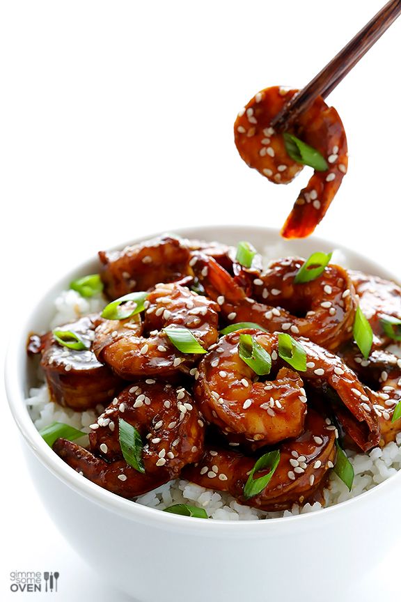 a white bowl filled with rice covered in sauce and meat chopsticks sticking out of it