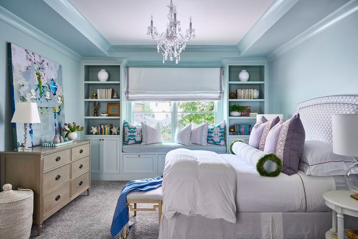 a bedroom with blue walls and white furniture