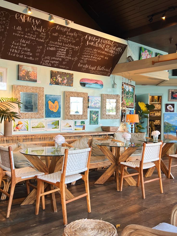 the inside of a restaurant with tables, chairs and chalkboards on the wall above them