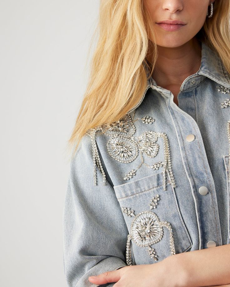 Upgrade your wardrobe with our VENICE denim jacket. This embellished denim shacket features rhinestone florals for a touch of glamour. Crafted with quality and style in mind, this jacket will elevate your outfits and make you stand out. Light wash embellished denim jacket Snap buttons Front pockets Length: 27.25" 75% cotton 24% polyester 1% spandex Hand wash Emma is 5ft 10in and is wearing a size small Imported Spring Denim Embellished Outerwear, Spring Embellished Denim Outerwear, Casual Denim Jacket With Rhinestones For Spring, Casual Rhinestone Denim Jacket For Spring, Embellished Long Sleeve Denim Jacket For Fall, Long Sleeve Embellished Denim Jacket For Fall, Spring Denim Jacket With Rhinestones, Spring Rhinestone Denim Jacket, Embellished Long Sleeve Summer Outerwear