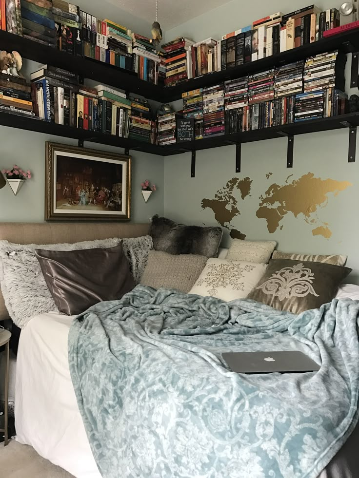 a laptop computer sitting on top of a bed in a room with bookshelves