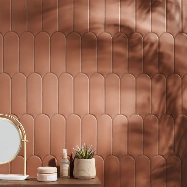 a bathroom with a mirror, sink and potted plant on the counter next to it