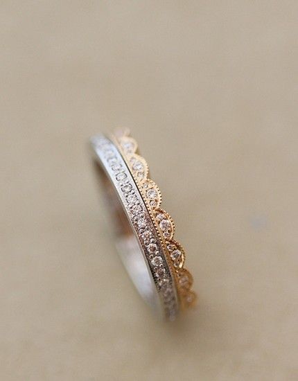 two tone gold and silver wedding bands with diamonds on them, sitting on a table