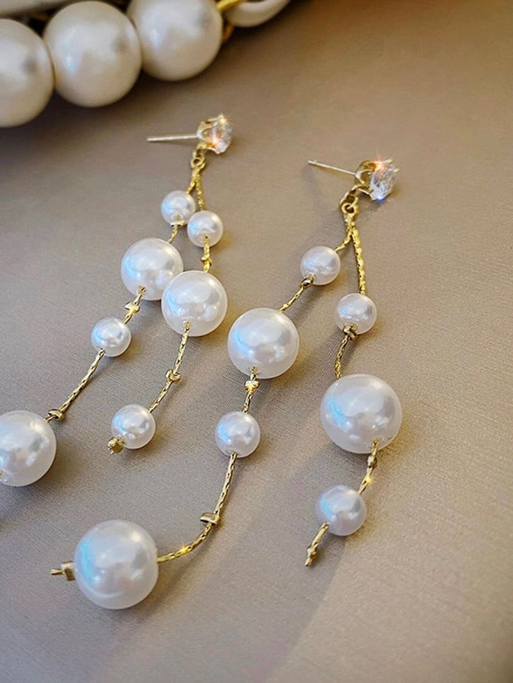 Bridal pearl dangle earrings with S925 genuine Sterling Silver posts. Floating Pearls on Dual strand of 14K Gold plated chain. Wedding white pearl multi strand dangle stud earrings.Just like drops of champagne, the multi sized white pearls are floating on a shiny 14K Gold plated chain from top to bottom and connect to a sparkling CZ diamond stud. The earrings is a perfect choice for brides, bridesmaids and wedding guests. The ear posts are made out of 925 Sterling Silver, plated over with 14K Go Cocktail Dinner, Pearl Dangle Earrings, Unique Shapes, Wedding White, Pearl Cluster, Dangly Earrings, Pearl Earrings Dangle, Big Earrings, Gold Plated Chains