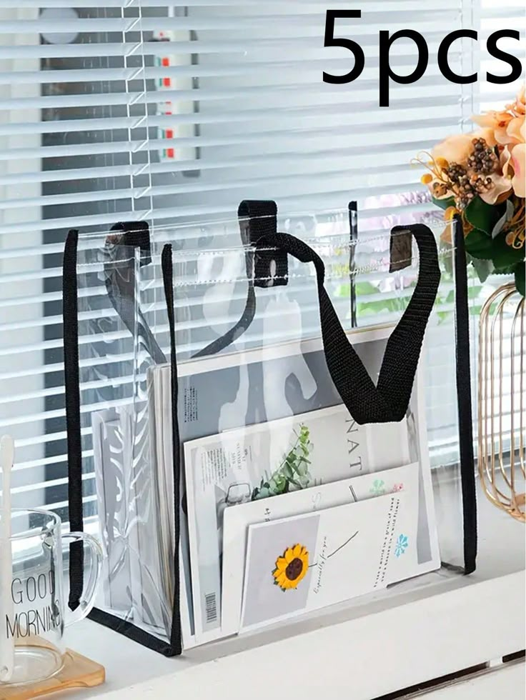 three clear bags sitting on top of a window sill next to flowers and vases