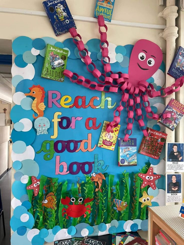 a bulletin board with an octopus and sea animals on it's side, surrounded by books