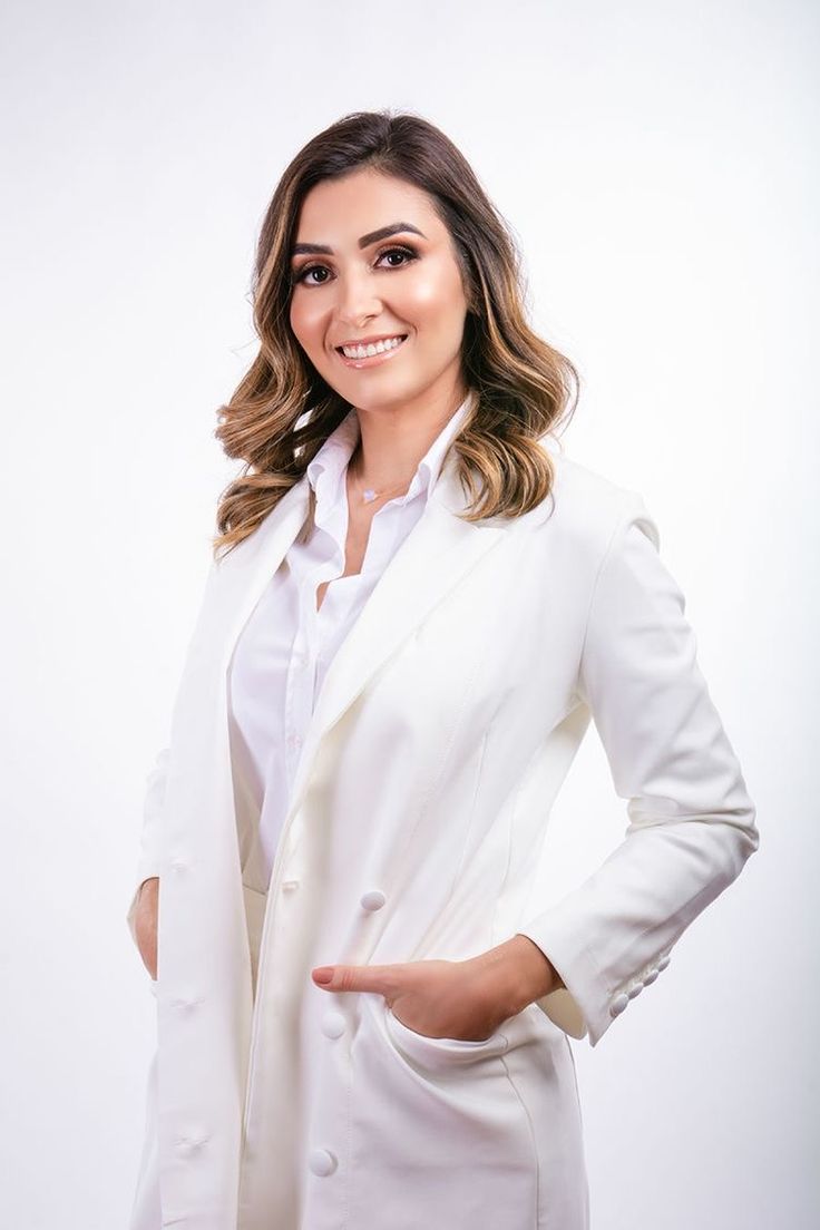 a woman in a white suit posing for the camera with her hands on her hips