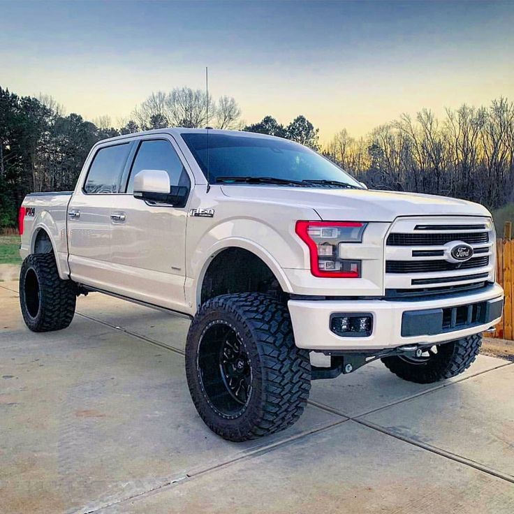 a white truck parked on top of a driveway