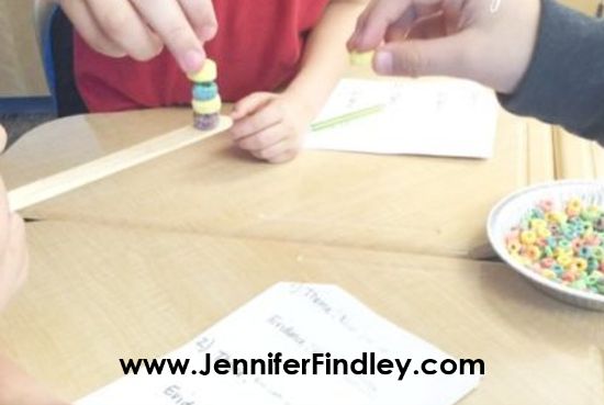 three children are sitting at a table playing with beads and pencils in front of them