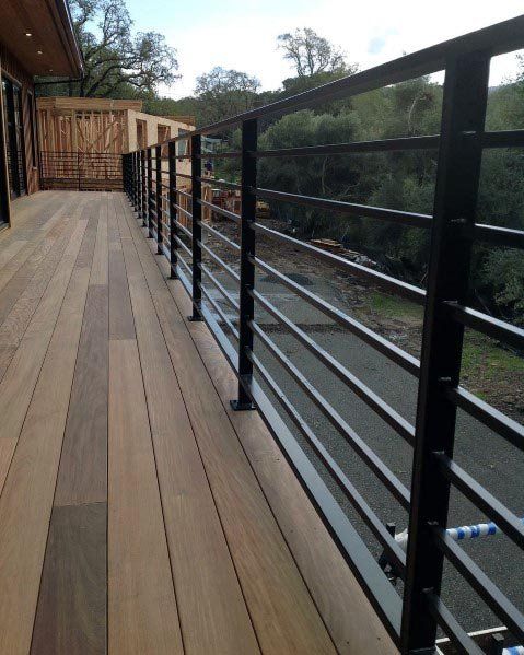 a wooden deck with metal railings and rails