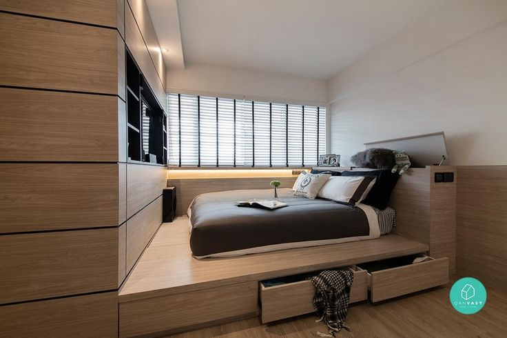 a bed sitting on top of a wooden platform next to a window covered in blinds