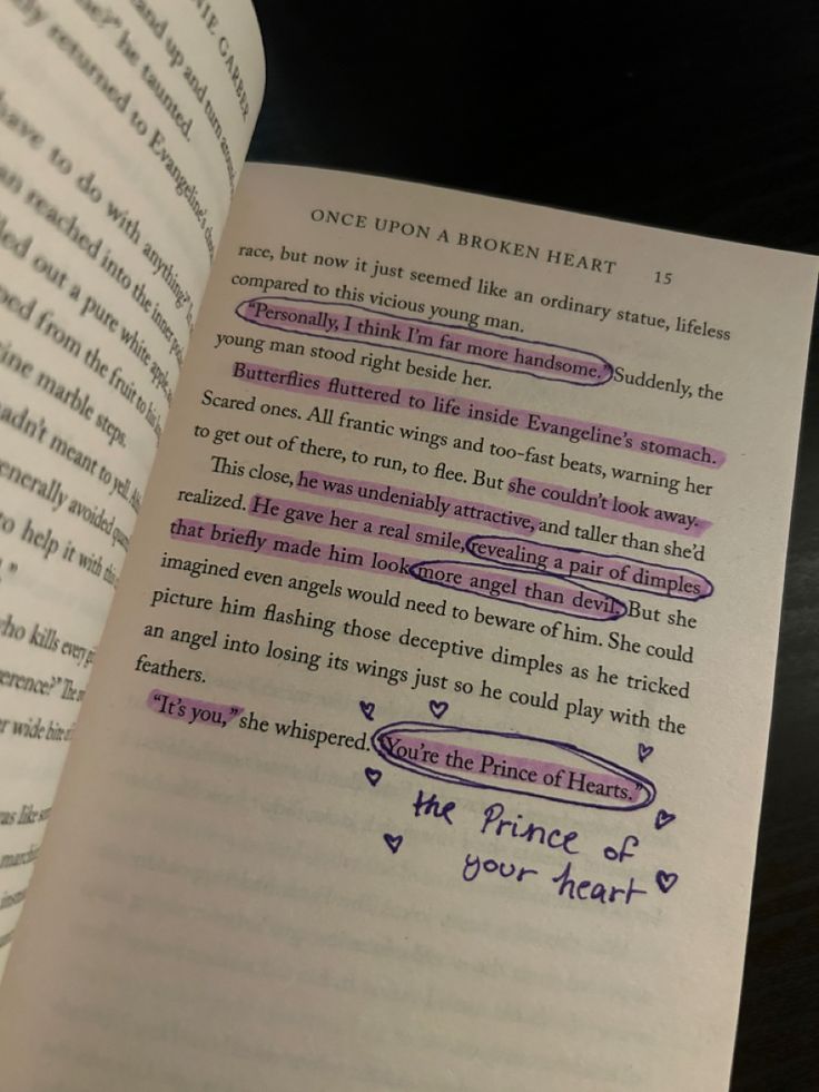 an open book with writing on the page and some words written in purple ink next to it