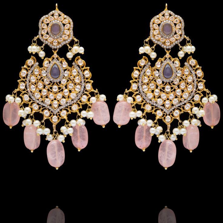 Indulge in the allure of this exquisite jewelry set and let contemporary grace redefine your fashion narrative! Radiate elegance and dangle in delight with our enchanting Esha Set – a mesmerizing blend of elegance and vibrancy meticulously crafted with sparkling zircons, complemented by the refreshing allure of lilac stones and dangling pink beads to elevate your style with the perfect harmony of sophistication and playfulness. The set includes a necklace, a maang teekah and a pair of trendy ear Elegant Bridal Earrings With Stone Work In Cubic Zirconia, Elegant Stone Work Bridal Earrings For Reception, Elegant Bridal Earrings With Stone Work For Reception, Intricate Dangle Jewelry For Reception, Reception Dangle Jewelry With Intricate Design, Elegant Jeweled Jewelry Sets For Reception, Elegant Cubic Zirconia Chandbalis For Festive Occasions, Elegant Pink Bridal Earrings With Stone Work, Elegant Wedding Chandelier Earrings With Stone Work