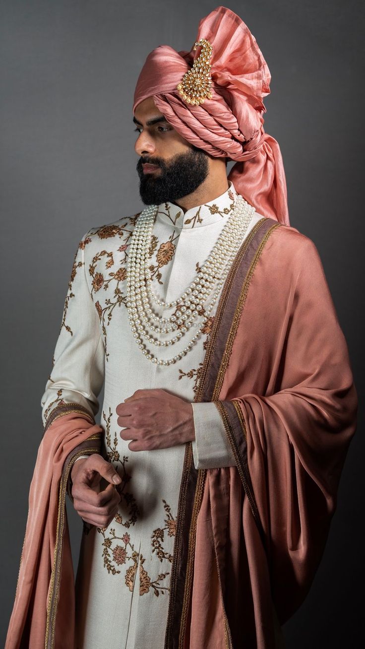 a man wearing a pink turban and pearls