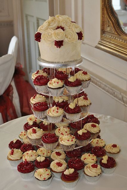 cupcakes are stacked on top of each other in front of a cake stand