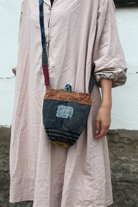 a woman wearing a pink dress holding a brown and blue bag with an elephant on it