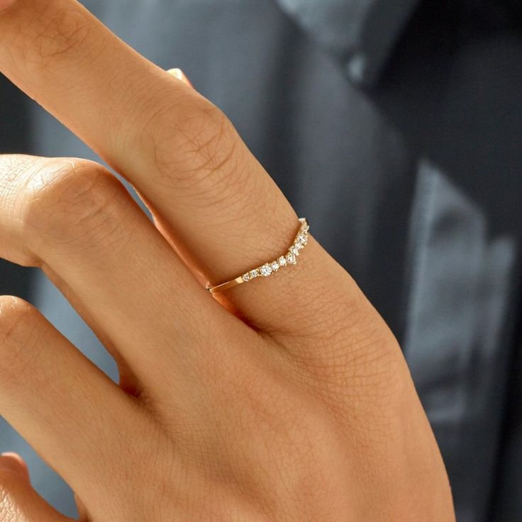 a close up of a person's hand with a diamond ring on their finger