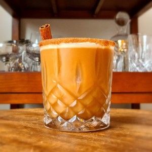 an orange drink sitting on top of a wooden table