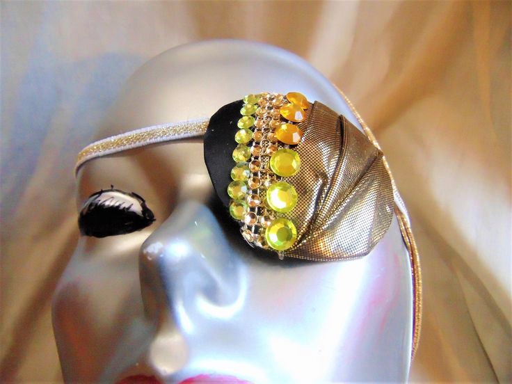 Women's eye patch, "ENTICEMENT" expertly handmade with metallic gold fabric creatively creased, mesh rhinestones and gemstones. The backing is soft recycled fabric for comfort. This is a ONE OF A KIND haute couture accessory. Wear it for a fashion statement or for an eye ailment such as cataracts. One size fits all and ideal for either eye. Adjustable Gold Headband For Festive Occasions, Bedazzled Gold Jewelry For Party, Gold Bedazzled Jewelry For Party, Party Gold Bedazzled Jewelry, Handmade Adjustable Gold Headpiece, Adjustable Gold Headband For Party, Adjustable Bedazzled Gold Jewelry, Adjustable Gold Headpieces For Evening, Gold Rhinestone Headpieces For Party