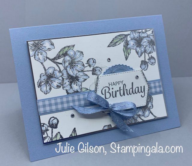 a blue and white birthday card with flowers on the front, ribbon around the edge