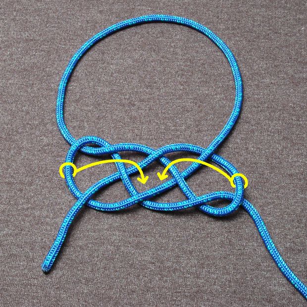 a blue rope with yellow ends on a gray surface next to a pair of scissors