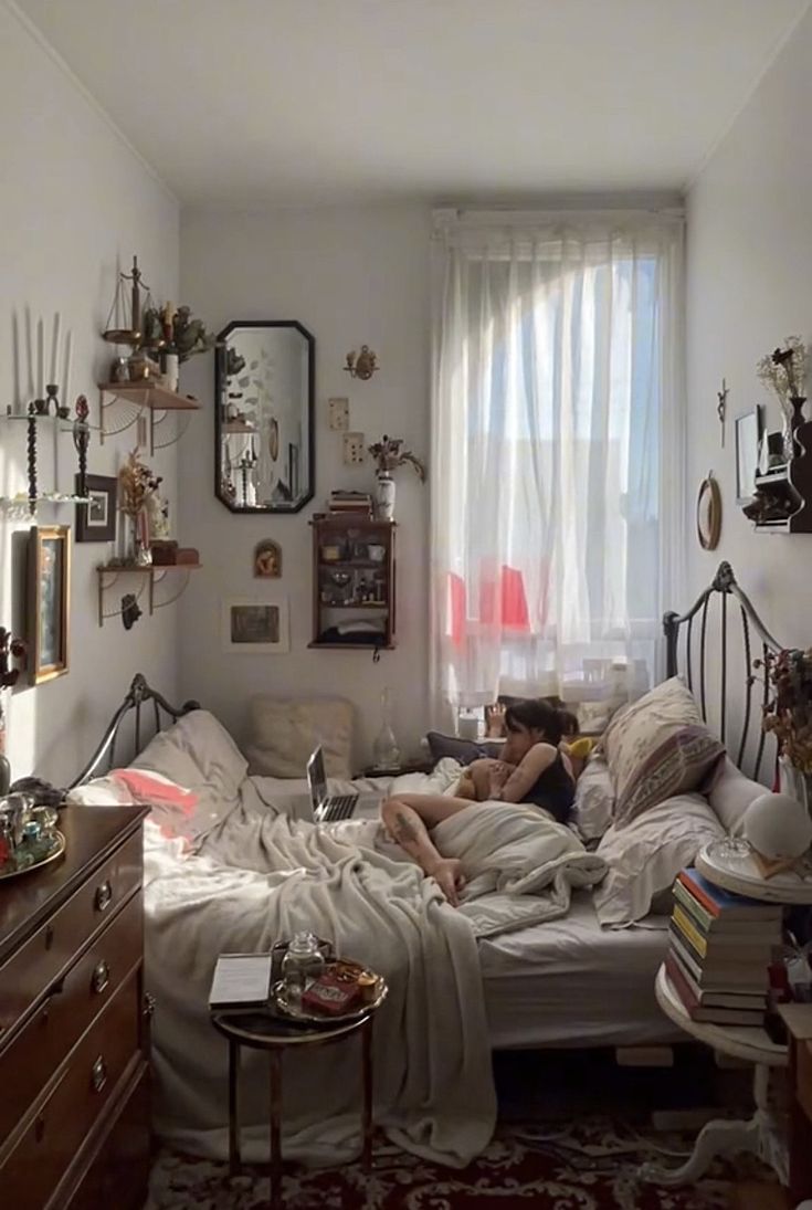 a person laying on a bed in a room with lots of clutter and decorations