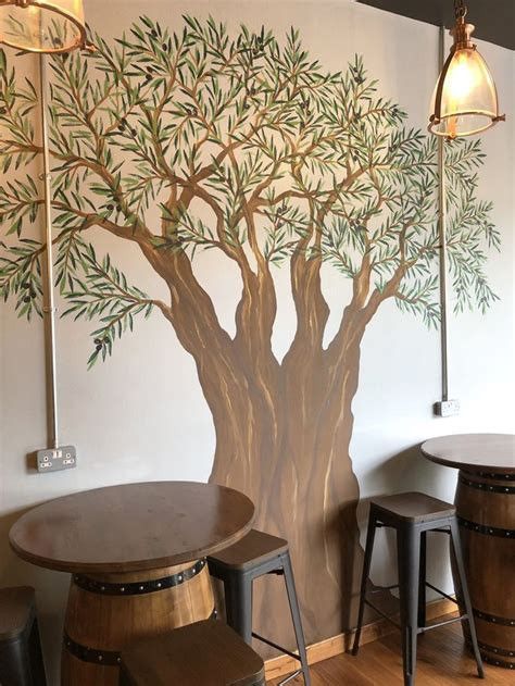 a tree painted on the wall next to stools