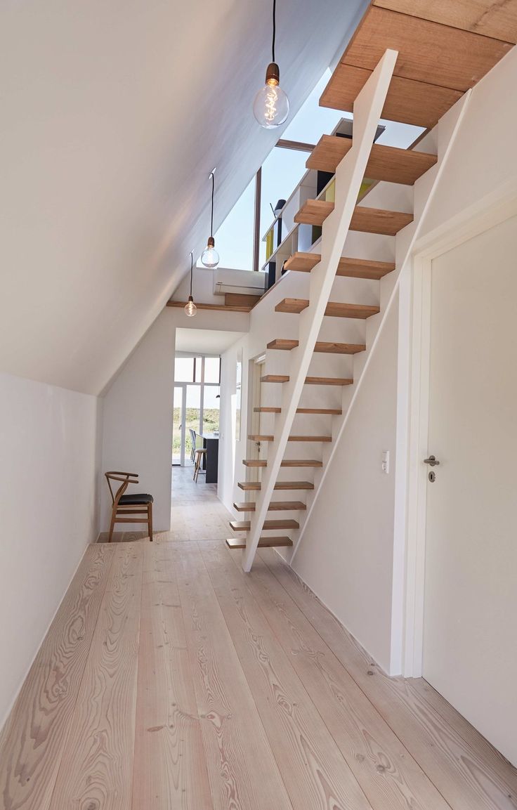 an empty room with wooden floors and stairs