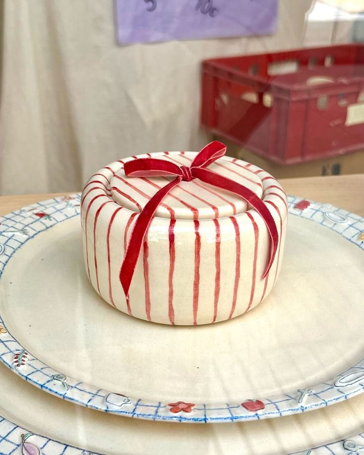 there is a cake that has been decorated with red ribbon on it and sits on plates