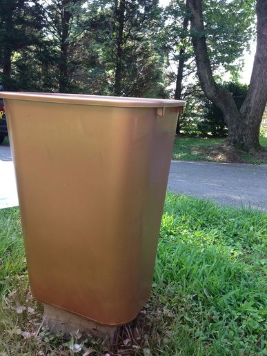 a metal trash can sitting in the grass