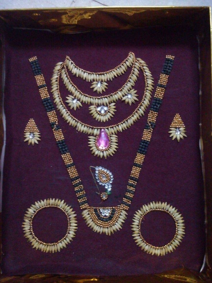 an ornate necklace and earring set in a wooden box