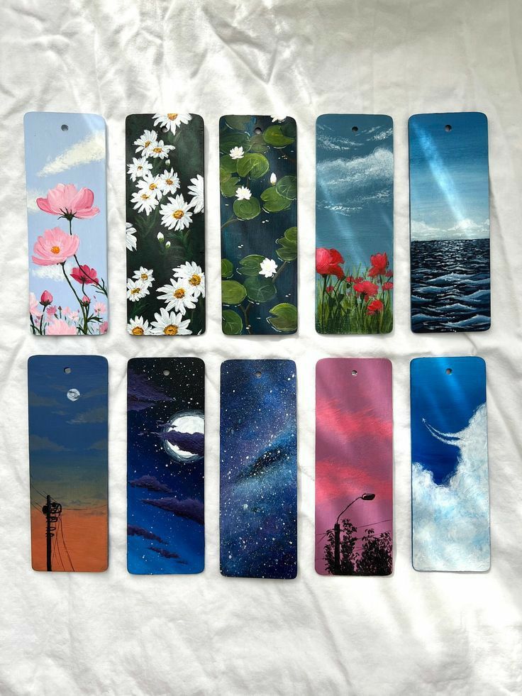 six different phone cases sitting on top of a white sheet with water and flowers painted on them