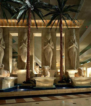 the interior of a hotel with statues and palm trees in it's lobby area