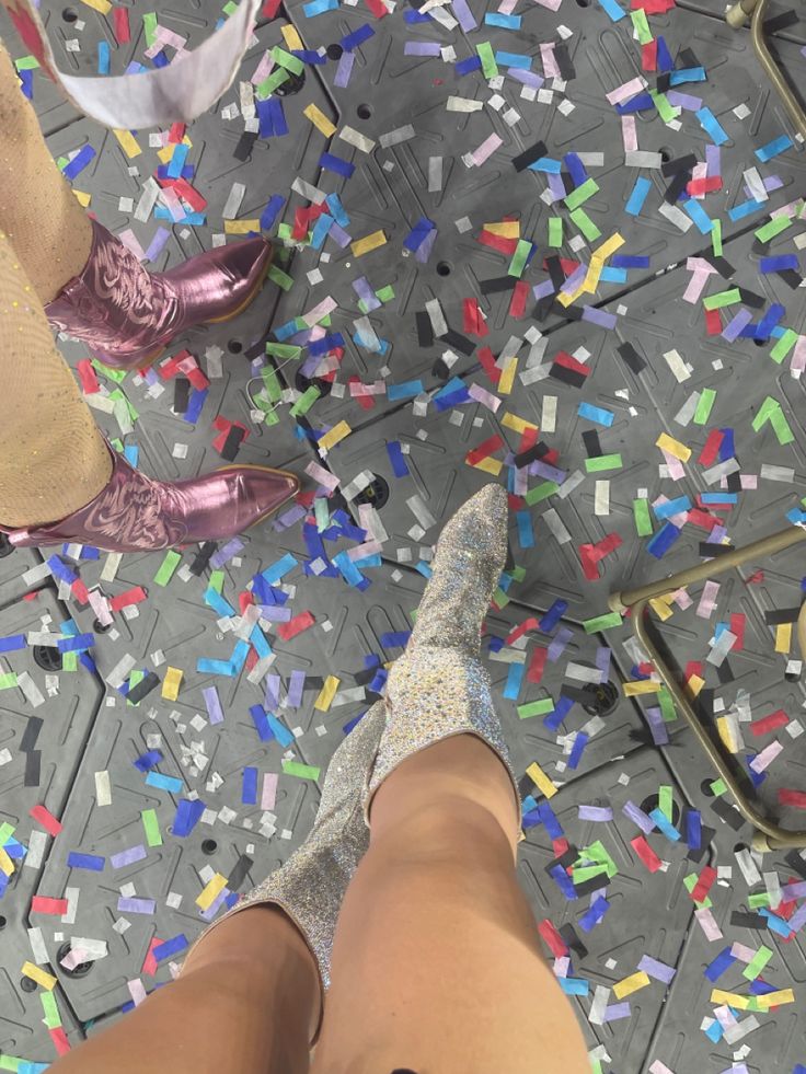 the legs and ankles of a woman standing on a floor covered in confetti