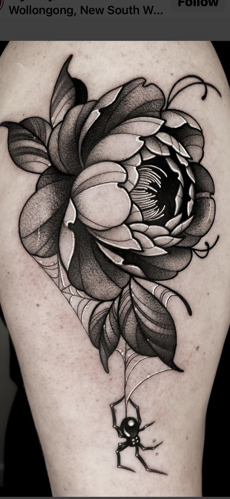 a black and white flower tattoo on the back of a woman's thigh,