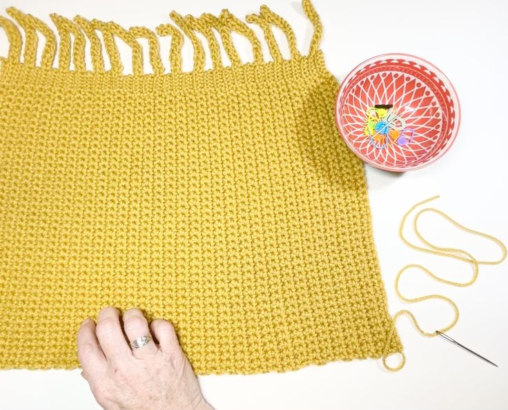 someone is working with yarn to make a crochet skirt for their child's bed