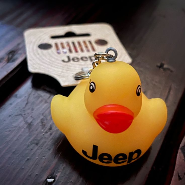 a rubber ducky keychain sitting on top of a wooden table