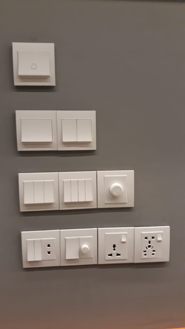 three switches and two outlets are on the wall next to each other in this room