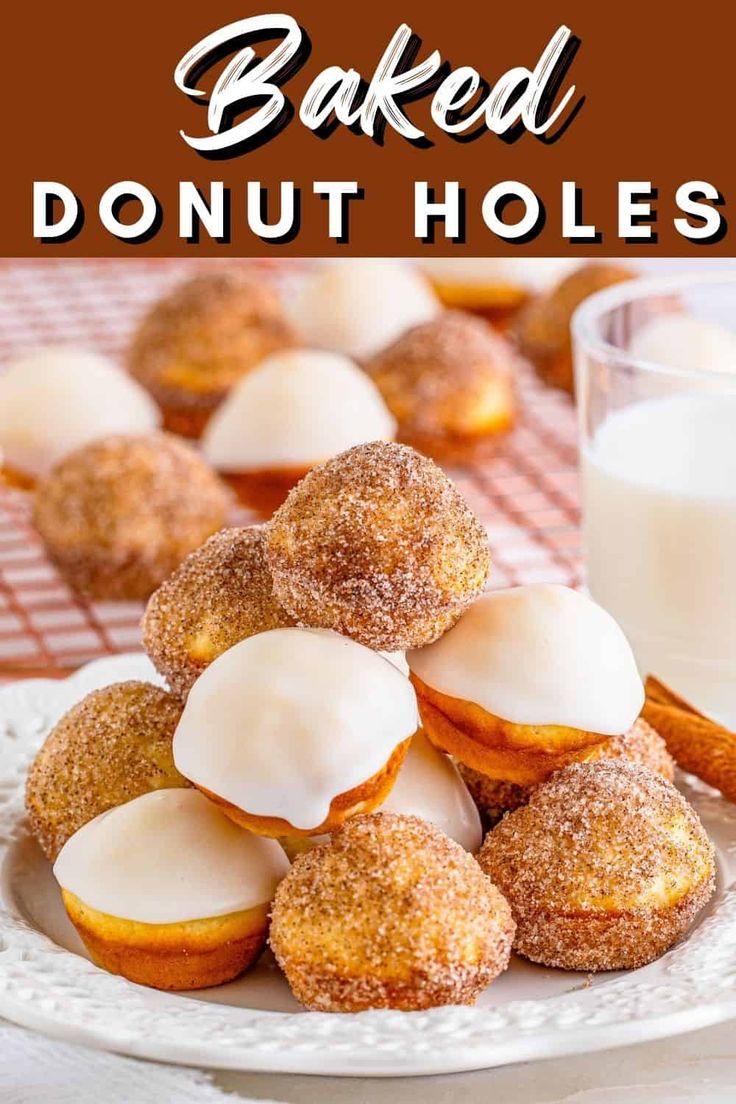 baked donut holes on a plate next to a glass of milk and cinnamon sticks