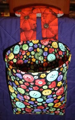 the back of a quilted bag with buttons on it, hanging from a hook