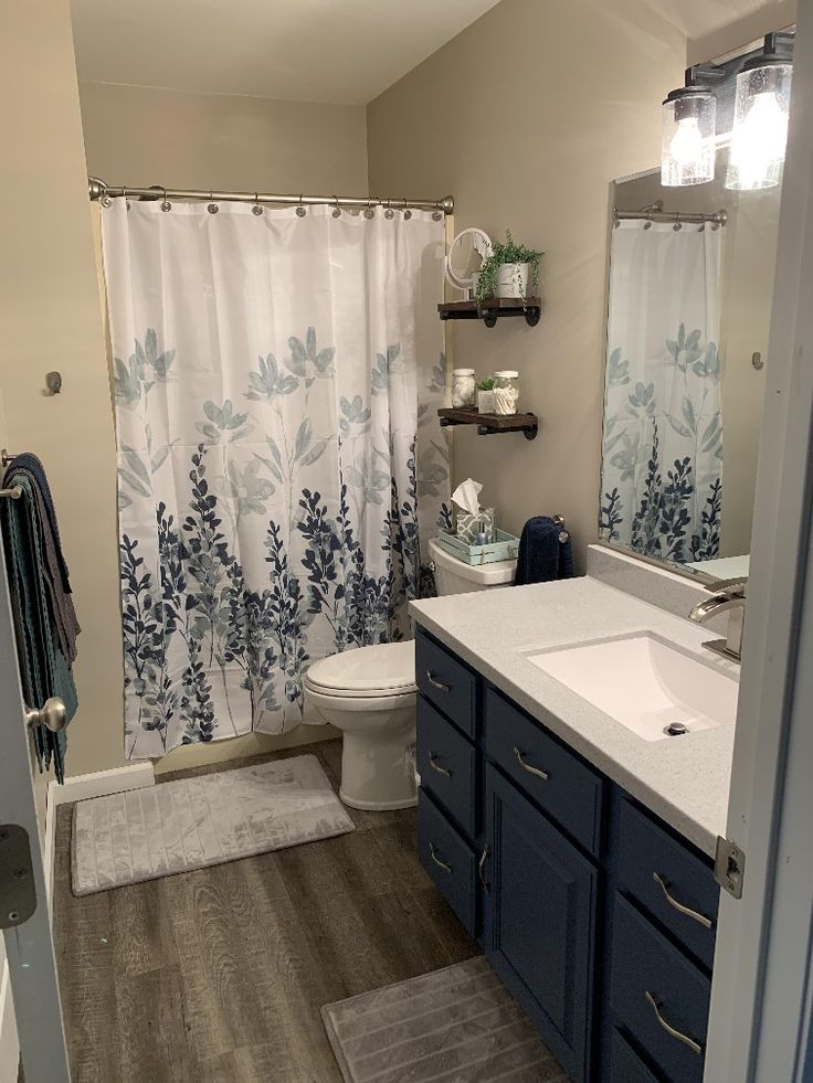 a bathroom with blue and white shower curtains