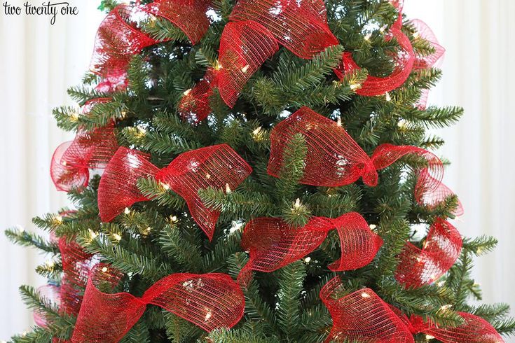 a christmas tree decorated with red bows and lights