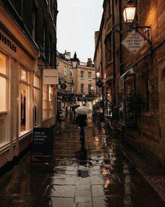 a person walking down an alley way in the rain