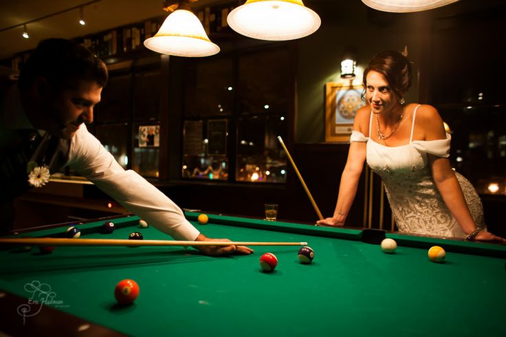 a man and woman playing pool in a bar