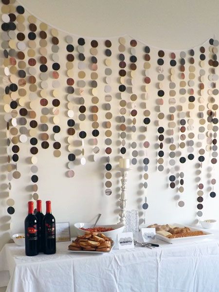 a table topped with plates and bottles of wine next to a wall covered in confetti