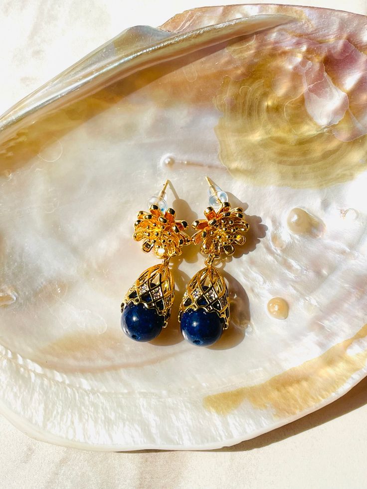 LAPIS LAZULI BLOOM EARRINGS Lustrous Gemstones: The Lapis Lazuli Bloom Earrings feature a design inspired by the delicate beauty of blooming flowers. At the heart of each earring, the deep blue Lapis Lazuli gemstones, known for their association with inner wisdom and truth, take center stage. Surrounding them is a meticulously crafted flower detail in 18K gold plated stainless steel, adding a touch of floral grace and sophistication to the design. Delicate Flower Detail: Lapis Lazuli Bloom Earri Elegant Lapis Lazuli Gemstone Earrings, Elegant Lapis Lazuli Earrings With Natural Stones, Sapphire Single Earring For Gift, Sapphire Single Earring As Gift, Teardrop Lapis Lazuli Earrings For Gift, Lapis Lazuli Teardrop Earrings As Gift, Lapis Lazuli Teardrop Earrings For Gifts, Elegant Lapis Lazuli Earrings, Elegant Lapis Lazuli Earrings As A Gift