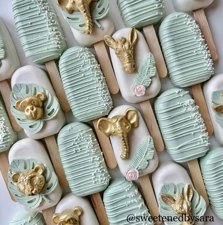 some green and white soaps with gold animal heads on them are arranged in rows