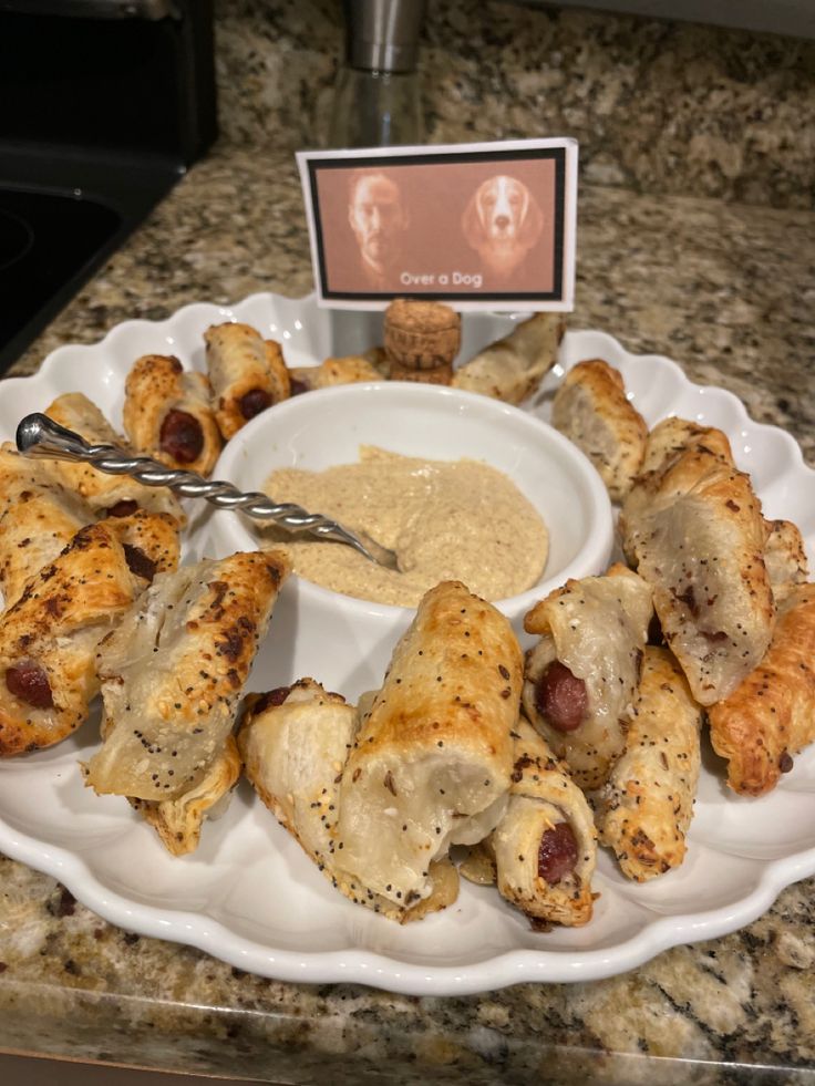 a white plate topped with food next to a bowl filled with sauce and chicken wings